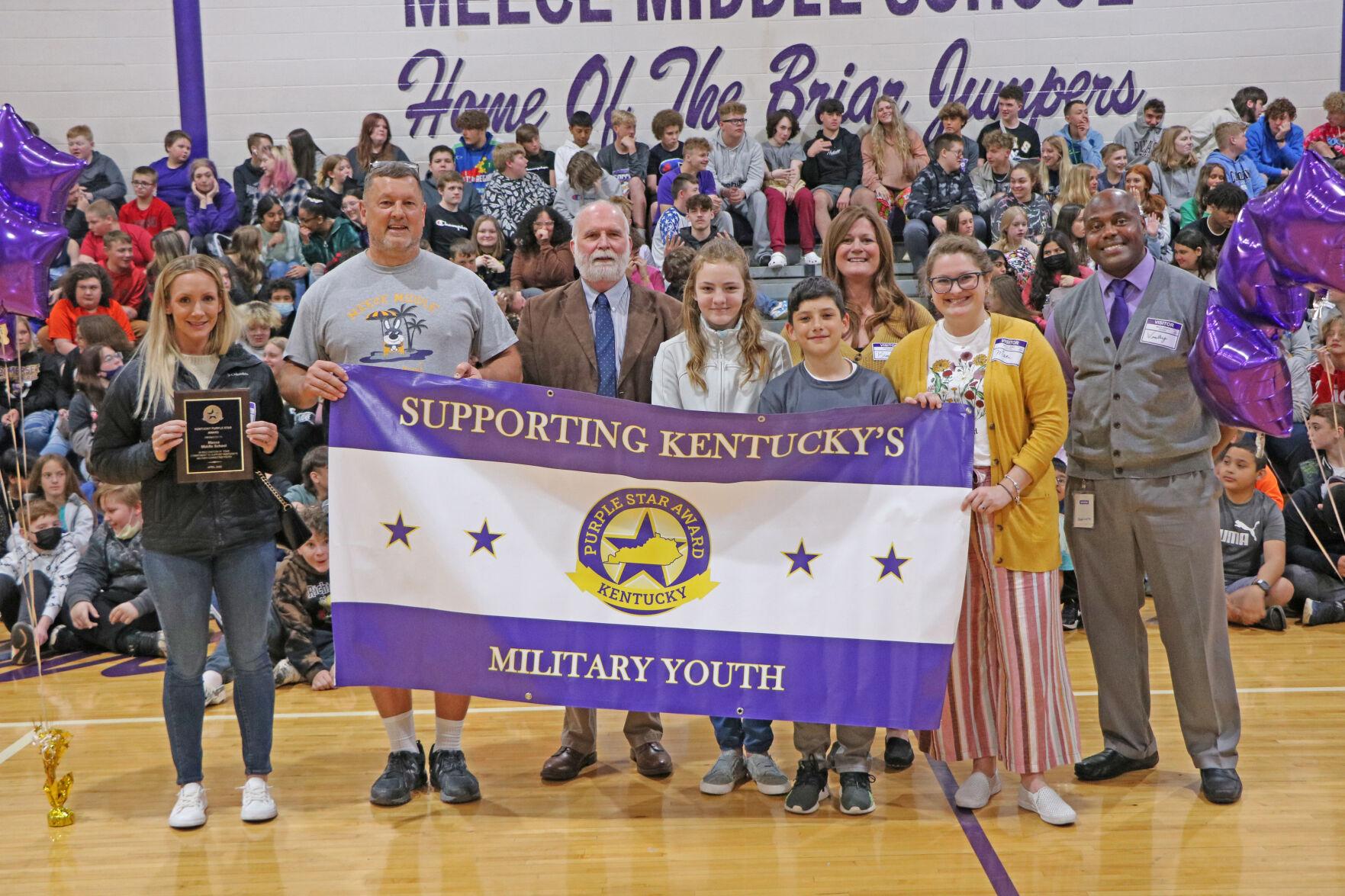 Students and staff at Meece Middle School hold their Purple Star Award sign during a ceremony.