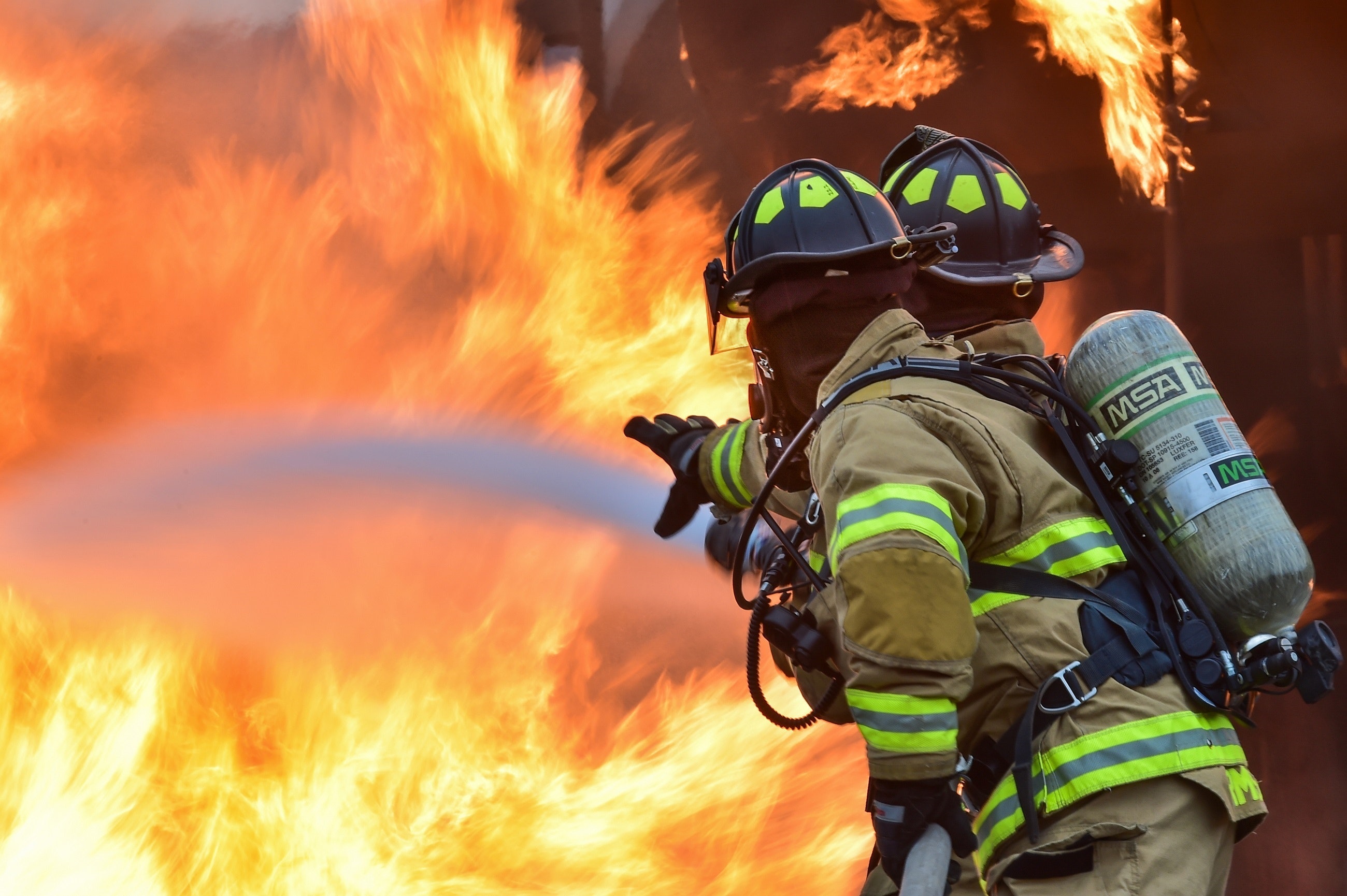 Firefighters spray water on a fire.