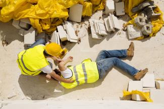 a picture of someone helping an injured fellow construction worker