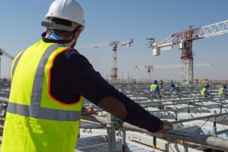 a photograph of a construction worker surveying a construction site