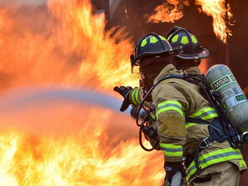 Firefighters spray water on a fire.