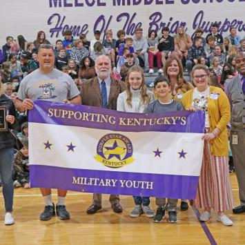 Students and staff at Meece Middle School hold their Purple Star Award sign during a ceremony.