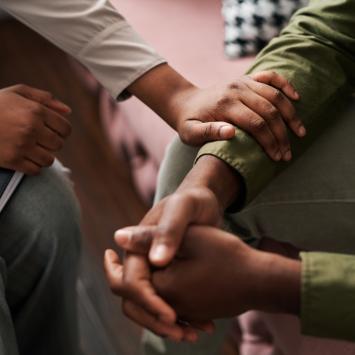 a pair of hands grasp each other while another hand holds the wrist